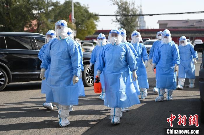 圖為醫(yī)務(wù)人員在封閉小區(qū)做防控工作?！⑽娜A 攝