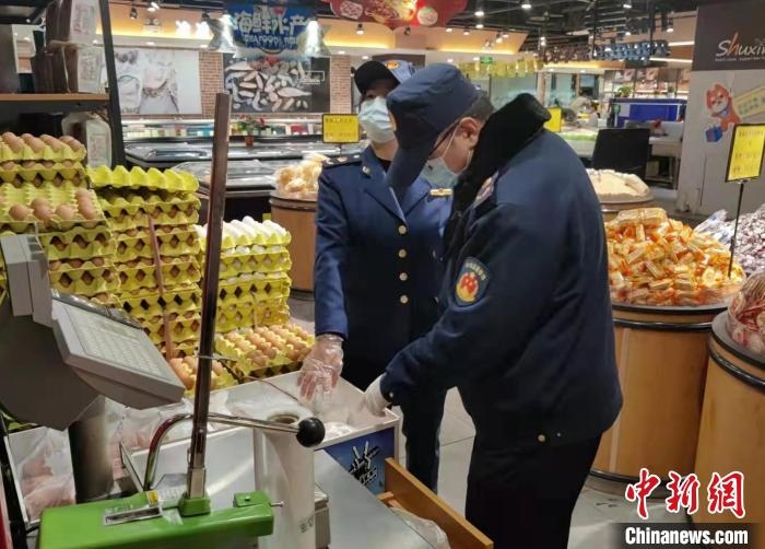 圖為疫情期間，甘肅嘉峪關(guān)市場監(jiān)管局工作人員檢查蔬菜市場?！?柴佳楠 　攝