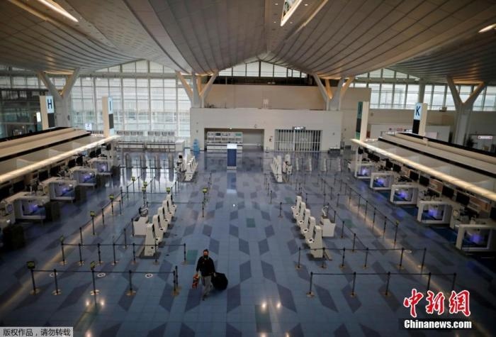 資料圖：日本東京，東京國際機(jī)場，一名乘客在國際航班航站樓的登機(jī)區(qū)。