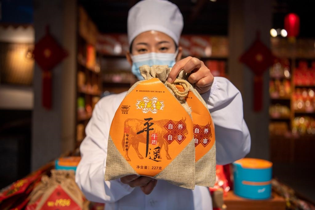 1月27日，在平遙古城南大街的一家平遙牛肉店內(nèi)，工作人員展示一款牛肉產(chǎn)品。新華社記者 楊晨光 攝