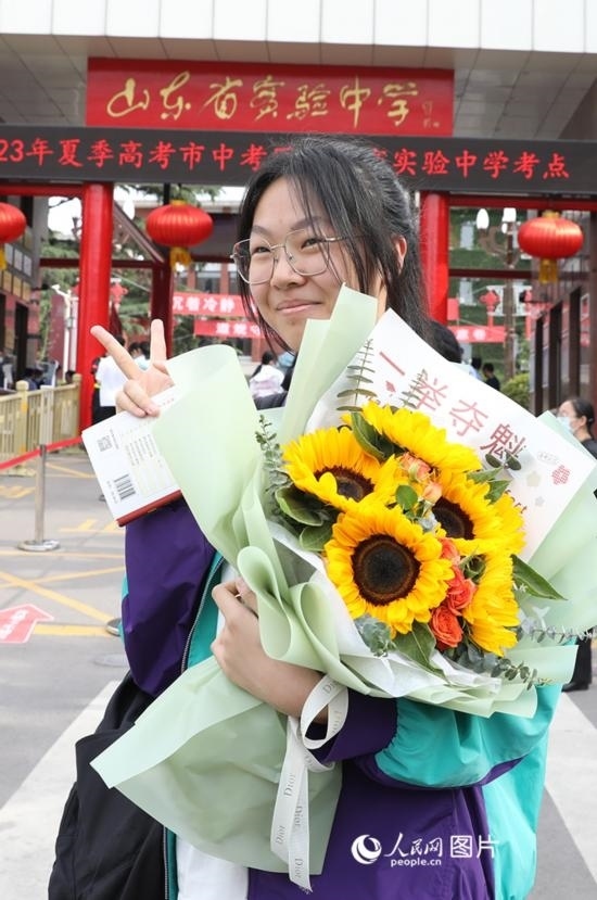 6月7日高考首日，山東67萬考生走進(jìn)考場，拼搏逐夢(mèng)。在山東省實(shí)驗(yàn)中學(xué)考點(diǎn)，考生進(jìn)考場前手捧向日葵花拍照留念，寓意“一舉奪魁”。人民網(wǎng)記者 劉祺攝