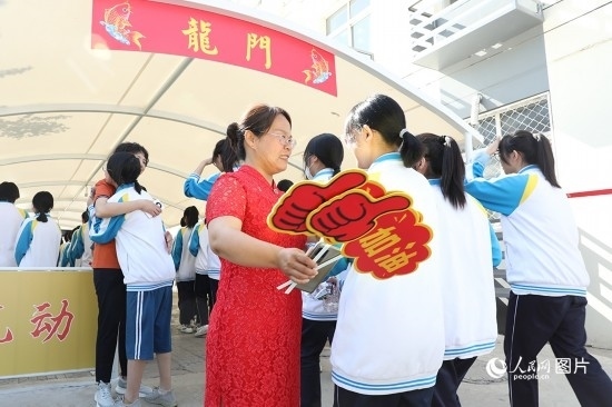 6月7日一早，雄安新區(qū)安新中學(xué)老師在給同學(xué)們加油鼓勁兒。人民網(wǎng) 李兆民攝