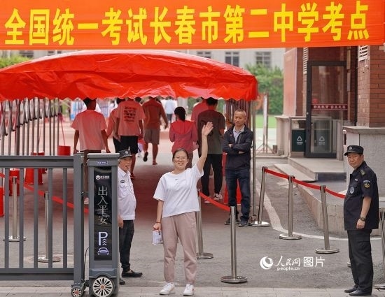 6月7日，在長春市第二中學(xué)考點(diǎn)，一名考生信心滿滿進(jìn)入考場，并與家長揮手致意。人民網(wǎng)記者 李洋攝