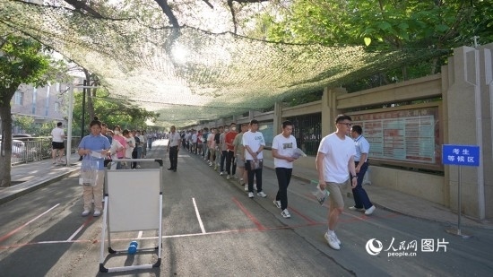 6月7日，烏魯木齊市第七十中學(xué)門口，考生們有序進(jìn)入考場。人民網(wǎng) 李欣洋攝