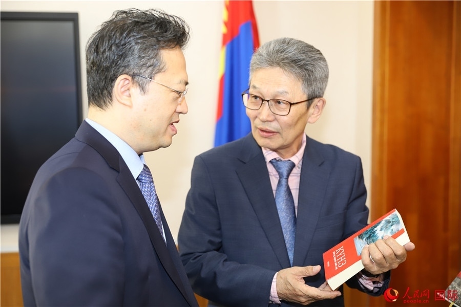 其米德策耶（右一）向李峙介紹翻譯成果。人民網記者 霍文攝