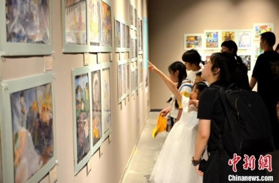 圖為家長帶著孩子參觀展覽。呂明 攝