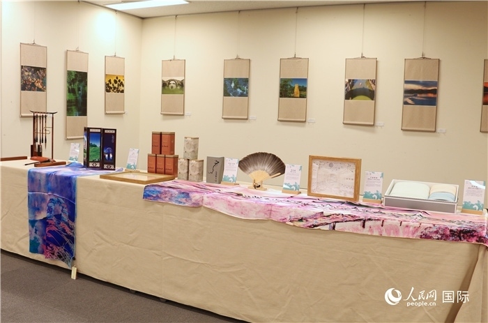 現(xiàn)場展出的馮學(xué)敏攝影作品與湖州市特色工藝品。（人民網(wǎng) 許可攝）