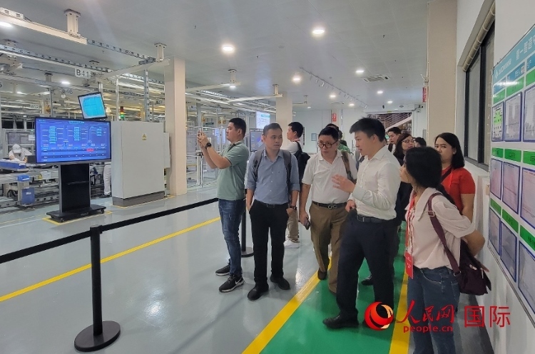 廣汽埃安工作人員向外媒記者進行介紹。人民網(wǎng) 寧玉瑛攝