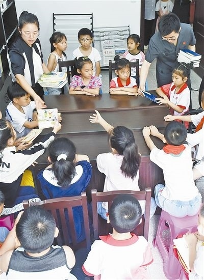  圖④：法院干警為留守兒童發(fā)放暑假讀物。