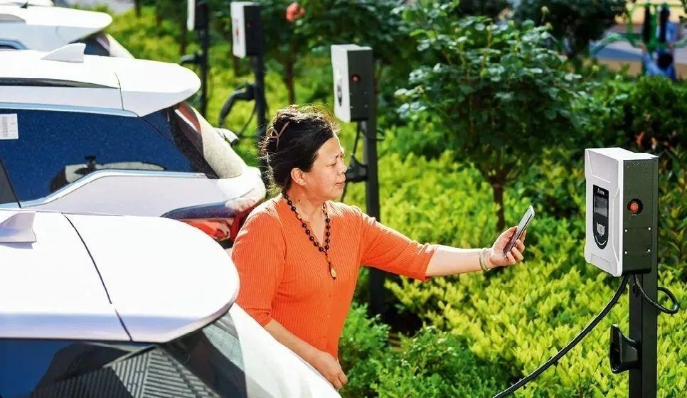 2023年5月24日，山東省膠州市新立街小區(qū)內(nèi)一位居民使用電動汽車充電樁掃碼充電。該小區(qū)加裝各類智慧設(shè)備，打造“智慧社區(qū)”，為居民生活帶來便利。