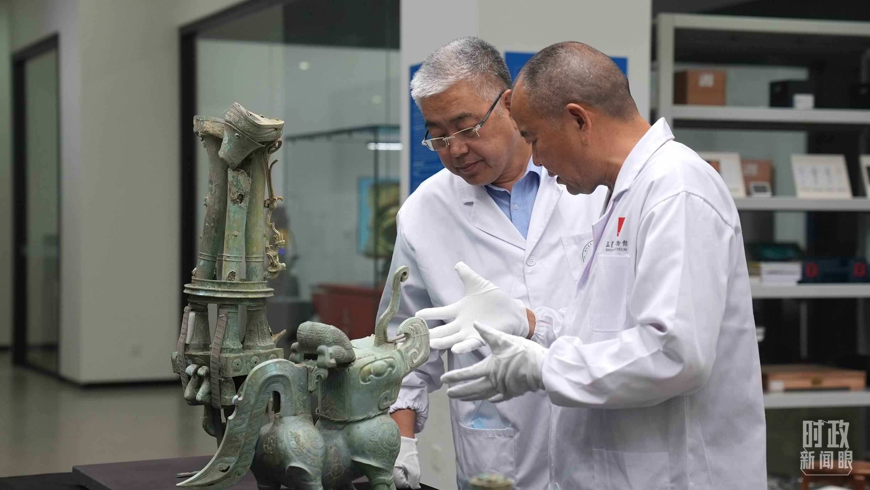 △三星堆文保專家正在就修復(fù)方案進(jìn)行討論。（總臺央視記者劉琦拍攝）
