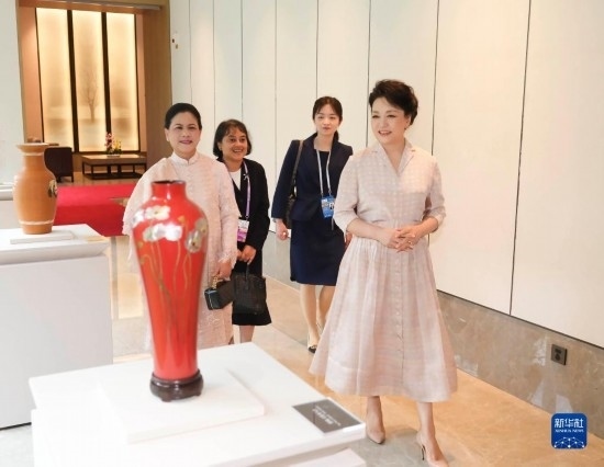 7月27日下午，國家主席習(xí)近平夫人彭麗媛在四川成都會(huì)見陪同印度尼西亞總統(tǒng)佐科來華出席第31屆世界大學(xué)生夏季運(yùn)動(dòng)會(huì)開幕式并訪華的總統(tǒng)夫人伊莉亞娜。這是彭麗媛和伊莉亞娜欣賞成都特色非遺工藝品。新華社記者 丁林 攝