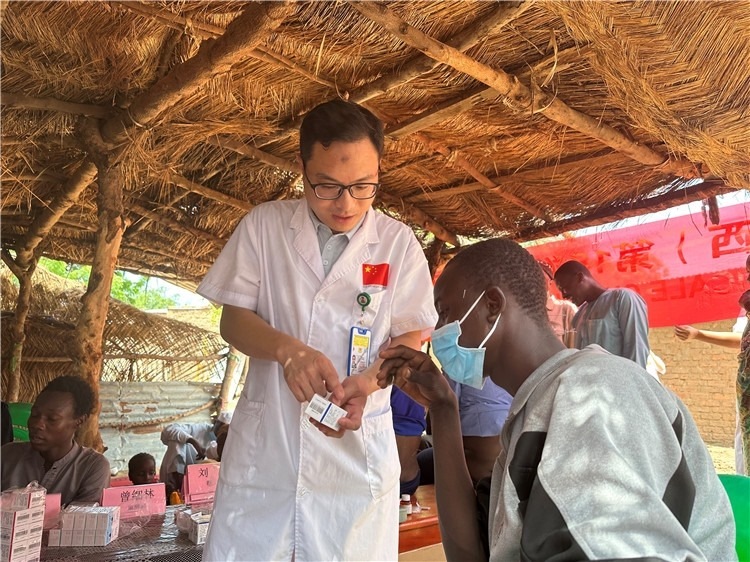 圖為南昌大學第一附屬醫(yī)院病理科主治醫(yī)師張振東為村民解說藥品使用方法。中國駐乍得醫(yī)療隊供圖