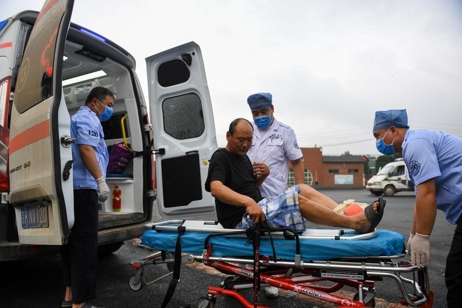 8月1日，在北京市門頭溝區(qū)妙峰山鎮(zhèn)妙峰山民族學(xué)校臨時(shí)安置點(diǎn)，北京急救中心工作人員在轉(zhuǎn)運(yùn)一名受傷村民。新華社記者 鞠煥宗 攝