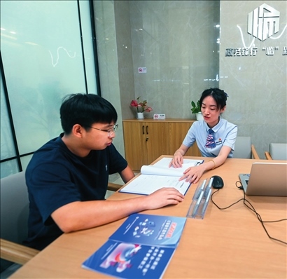 在杭州市臨安區(qū)政務(wù)服務(wù)中心的“為企服務(wù)中心”，黨員志愿者（右）解答企業(yè)主的疑問（2023年7月7日攝）。徐昱攝/本刊