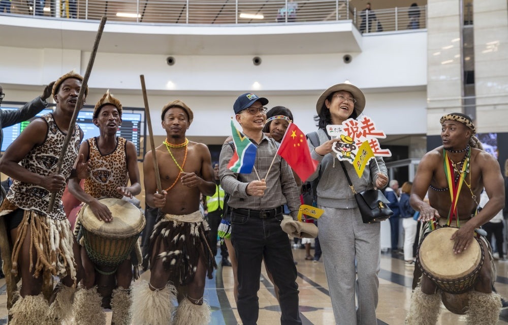 在南非約翰內(nèi)斯堡坦博國(guó)際機(jī)場(chǎng)，南非舞蹈演員歡迎中國(guó)試點(diǎn)恢復(fù)出境團(tuán)隊(duì)旅游后首批抵達(dá)南非的中國(guó)游客（2023年3月29日攝）。