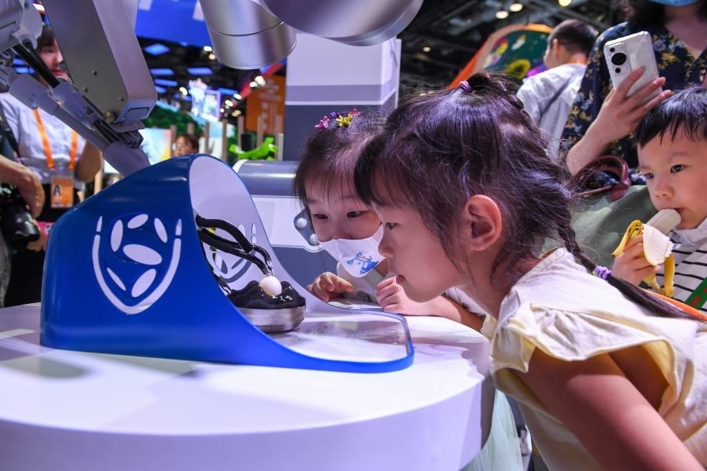 9月3日，幾名小朋友在國家會(huì)議中心觀看單孔腔鏡手術(shù)機(jī)器人展示。新華社記者 鞠煥宗 攝