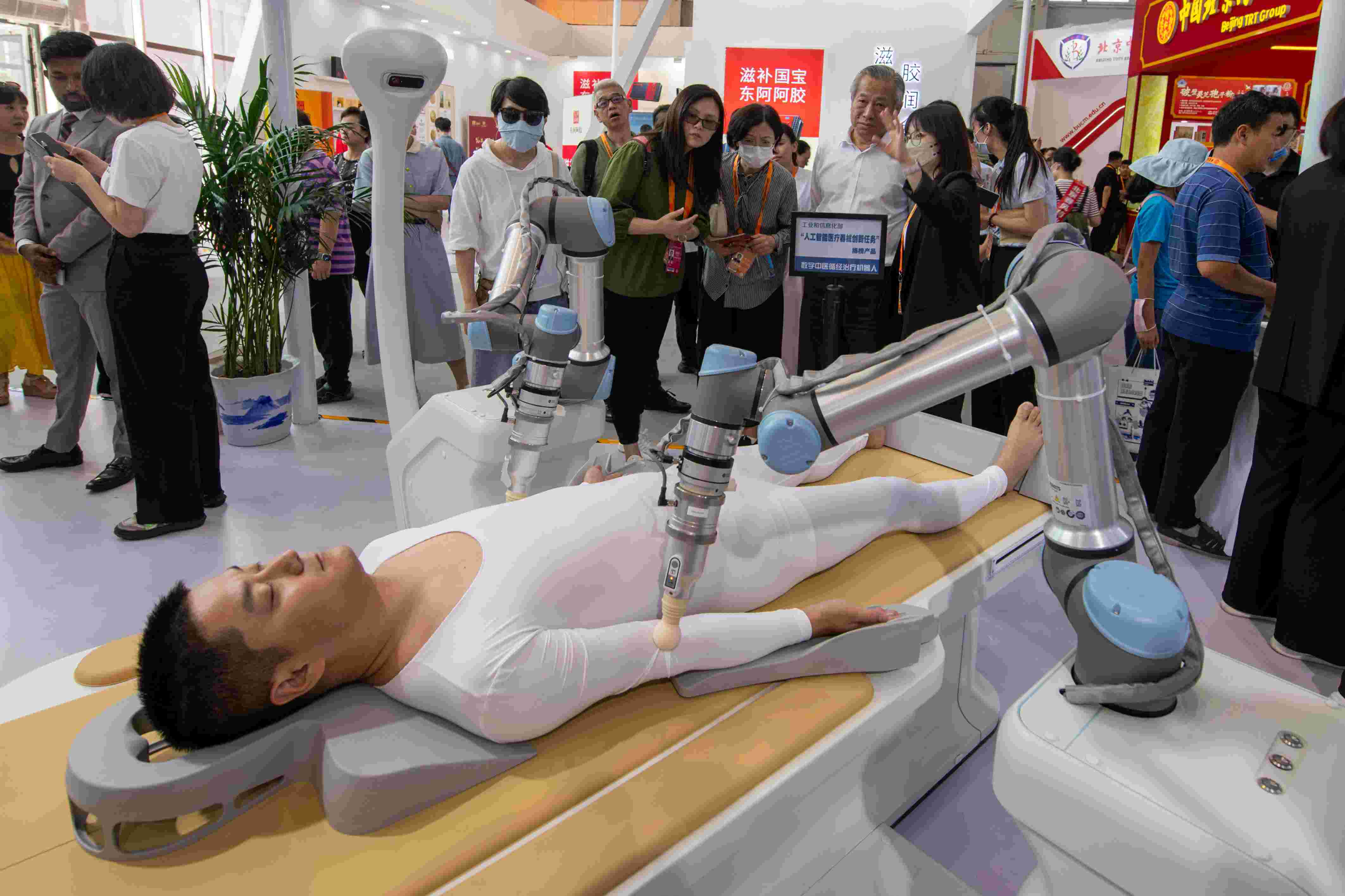 在位于首鋼園的健康衛(wèi)生服務展區(qū)，觀眾正在參觀數(shù)字中醫(yī)循經治療機器人。人民網(wǎng)記者 翁奇羽攝