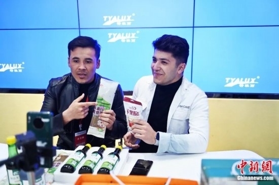 2023年3月，甘肅省慶陽市環(huán)縣電商創(chuàng)業(yè)孵化基地內(nèi)，來自蘭州文理學院的塔吉克斯坦留學生正在協(xié)助主播直播帶貨當?shù)剞r(nóng)特產(chǎn)品。李亞龍 攝