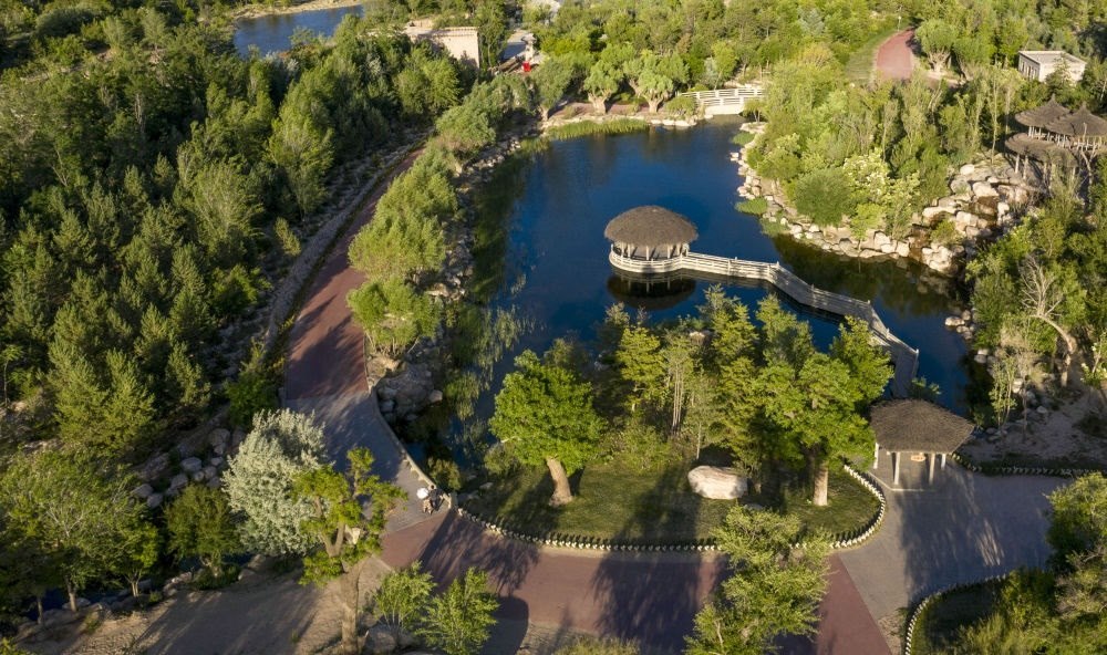 坐落在寧夏銀川市賀蘭山腳下的賀蘭山運(yùn)動(dòng)休閑公園（2021年5月27日攝，無人機(jī)照片）。這里曾是一片砂石采礦塌陷區(qū)，當(dāng)?shù)赝ㄟ^植被景觀再造、水系建設(shè)、現(xiàn)代管網(wǎng)鋪建等手段，重新利用廢石、廢坑及各類廢棄建筑材料，把這里變成一座免費(fèi)開放的主題公園。新華社記者 馮開華 攝