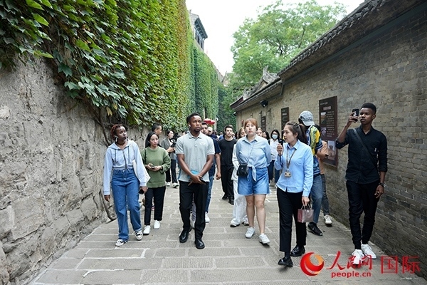 選手們認(rèn)真聆聽導(dǎo)游講解。人民網(wǎng) 盧鵬宇攝