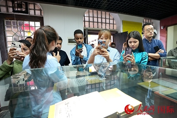 選手們認(rèn)真聆聽導(dǎo)游講解。人民網(wǎng) 盧鵬宇攝