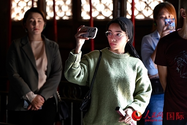 選手顏青（蘇丹）用手機(jī)記錄所見所感。人民網(wǎng) 盧鵬宇攝