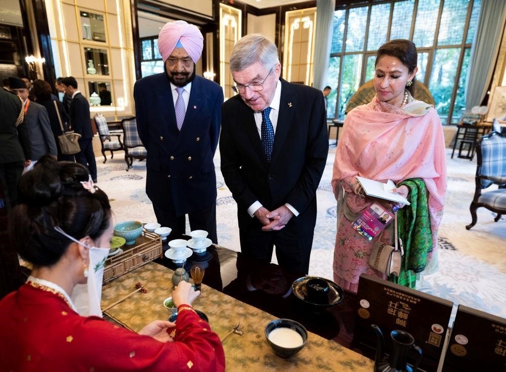 △歡迎宴會前，亞奧理事會代理主席辛格和夫人維尼塔、國際奧委會主席巴赫欣賞非遺展示。