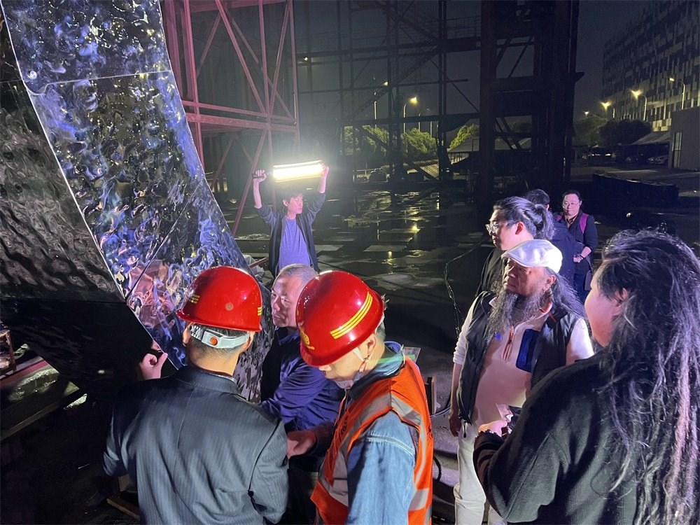 林崗（右二）和團(tuán)隊查看主火炬制作進(jìn)度。受訪者供圖