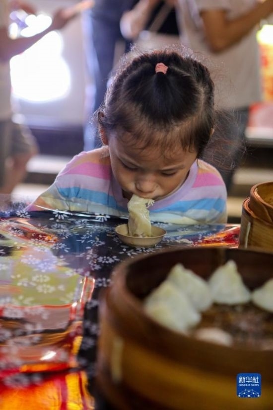 9月27日，小朋友在南翔小籠長街宴上品嘗南翔小籠。