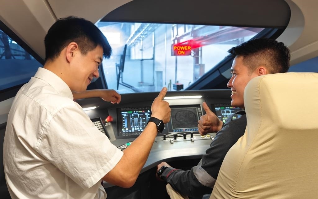 8月25日，在印度尼西亞萬(wàn)隆的雅萬(wàn)高鐵德卡魯爾動(dòng)車(chē)所內(nèi)，中國(guó)師傅穆振（左）在向印尼火車(chē)司機(jī)塞蒂亞萬(wàn)講解動(dòng)車(chē)組出庫(kù)前的上電作業(yè)。