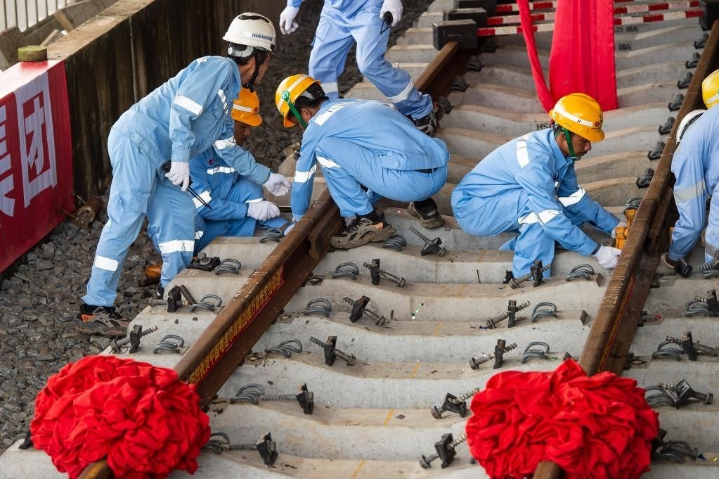 3月31日，在印度尼西亞雅加達(dá)雅萬(wàn)高鐵哈利姆車(chē)站，工人鋪設(shè)雅萬(wàn)高鐵全線最后一根鋼軌。