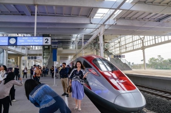  10月17日，在印度尼西亞萬(wàn)隆德卡魯爾站，乘客在站臺(tái)上和雅萬(wàn)高鐵高速動(dòng)車組列車合影。新華社記者 徐欽 攝