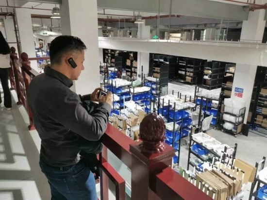 2023“一帶一路”媒體合作論壇聯(lián)合采訪團(tuán)團(tuán)員在仁和醫(yī)藥物流園拍攝記錄轉(zhuǎn)運(yùn)流程。（本報(bào)記者 黃超攝）