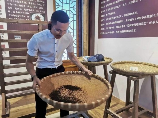 2023“一帶一路”媒體合作論壇聯(lián)合采訪團(tuán)團(tuán)員在非遺文化展示館體驗(yàn)中藥炮制技藝。（本報(bào)記者 黃超攝）