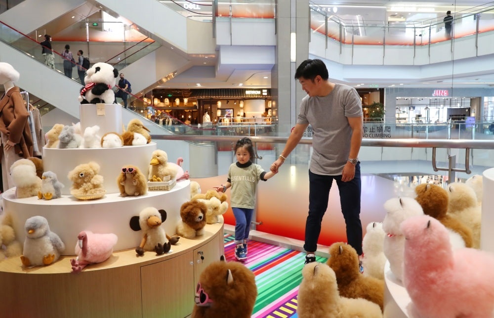 2023年11月2日，顧客在溫暖駝品牌專柜內(nèi)選購。連續(xù)六年參加進博會的秘魯羊駝制品品牌溫暖駝在上海市中心商場開設(shè)了專柜。新華社記者 方喆 攝