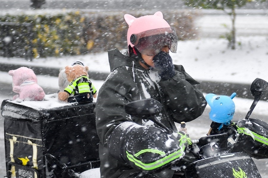 11月6日，在長(zhǎng)春市街頭，一名外賣員在雪中騎行。新華社記者 許暢 攝