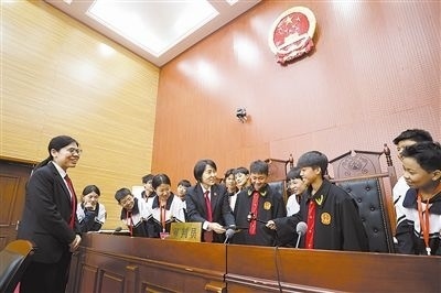 圖③：同學們穿法袍、敲法槌，爭做“小法官”。