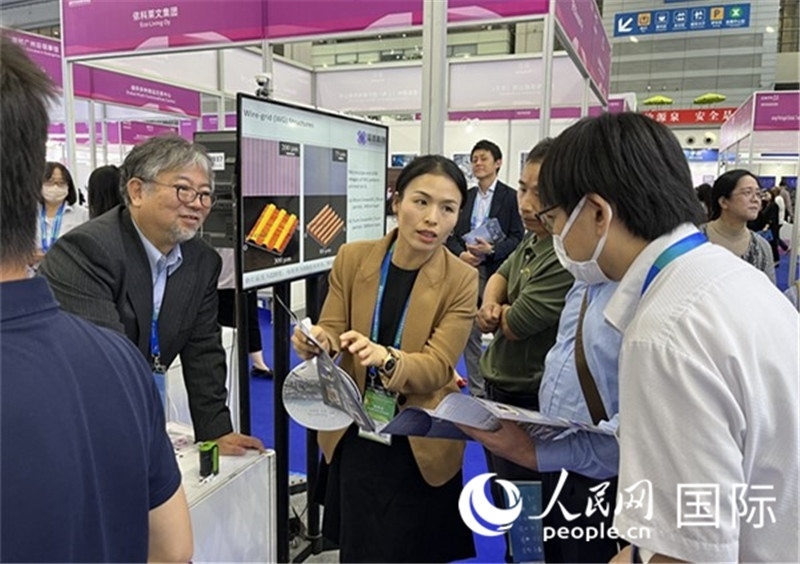 工作人員向參觀者介紹超級(jí)噴墨技術(shù)。（人民網(wǎng)記者 陳思攝）