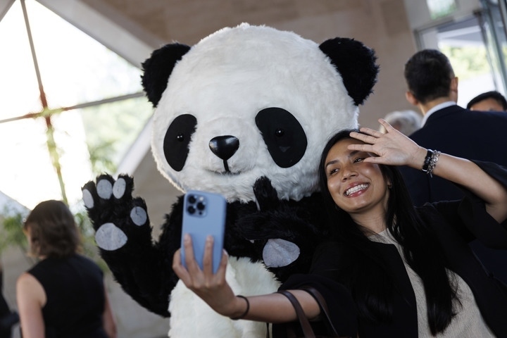 2022年8月24日，在美國華盛頓中國駐美國大使館，來賓與大熊貓玩偶合影。