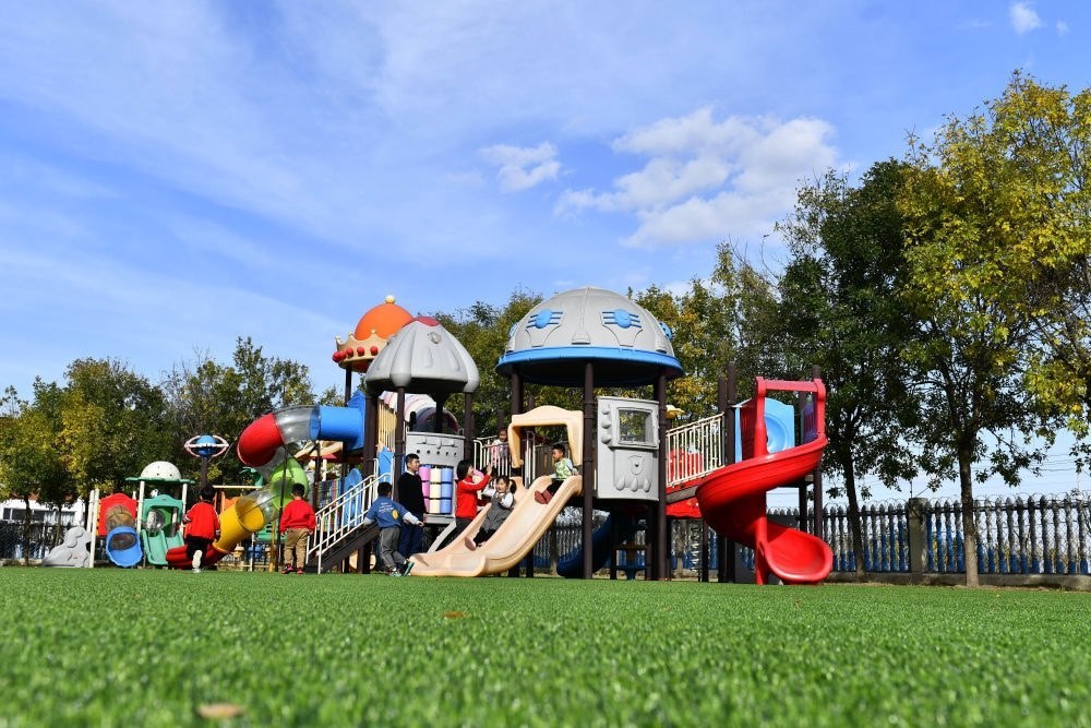 在山東省東營市墾利區(qū)楊廟社區(qū)幼兒園，孩子們在老師的帶領(lǐng)下進(jìn)行戶外活動(dòng)（2021年10月19日攝）。新華社記者 郭緒雷 攝