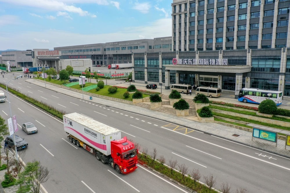 2023年10月11日，滿載筆記本電腦配件、發(fā)電機(jī)組件等產(chǎn)品的西部陸海新通道跨境公路班車從重慶南彭公路保稅物流中心駛出，將途經(jīng)廣西憑祥，直達(dá)越南（無人機(jī)照片）。新華社記者 黃偉 攝