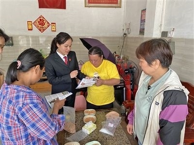  圖⑤：龍圩區(qū)法院法官到群眾家中開展法治宣傳。資料圖片