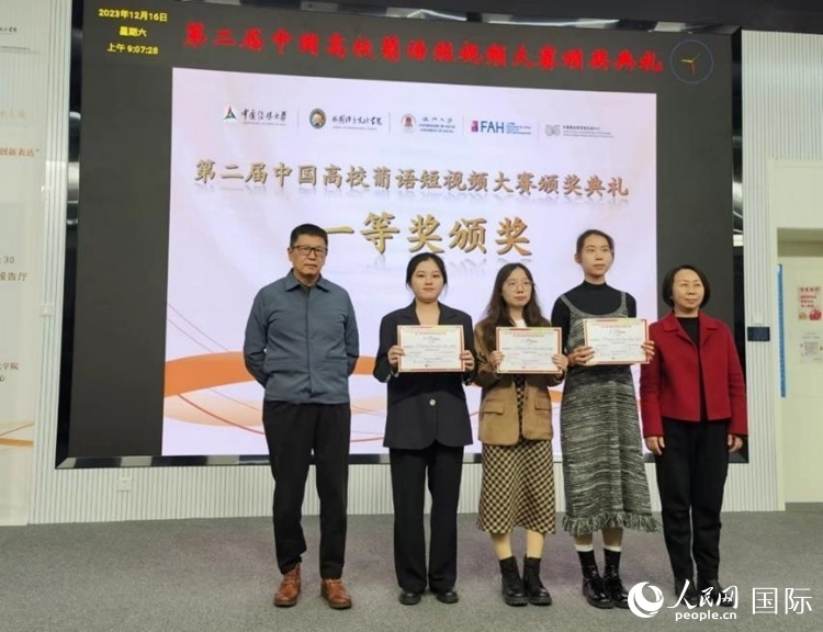 澳門大學中葡雙語教學暨培訓中心主任姚京明（左一）和中國傳媒大學外國語言文化學院院長文春英（右一）為一等獎獲得者頒獎。人民網記者 魯揚攝