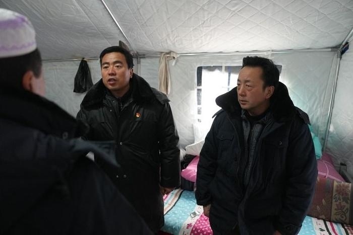 2023年12月22日，積石山縣大河家鎮(zhèn)大河村黨支部書記馬成忠（右二）在帳篷里和受災(zāi)群眾交流。新華社記者 陳斌 攝