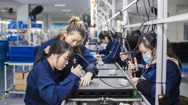 在新亞勝光電的產(chǎn)品線上，工人正進(jìn)行產(chǎn)品組建和安裝布線。受訪者供圖