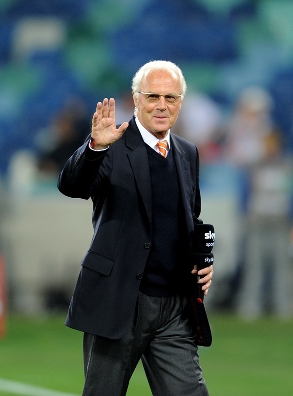 這是2010年7月7日，在南非德班舉行的2010年足球世界杯德國(guó)隊(duì)對(duì)陣西班牙隊(duì)的半決賽前，貝肯鮑爾接受電視臺(tái)采訪時(shí)和友人打招呼。新華社記者 王毓國(guó) 攝