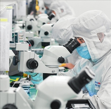 在位于武漢中國光谷的光電器件研發(fā)制造商——武漢光迅科技股份有限公司生產(chǎn)車間內(nèi)，技術(shù)人員在光模塊生產(chǎn)線作業(yè)（2023年4月11日攝）。程敏攝/本刊