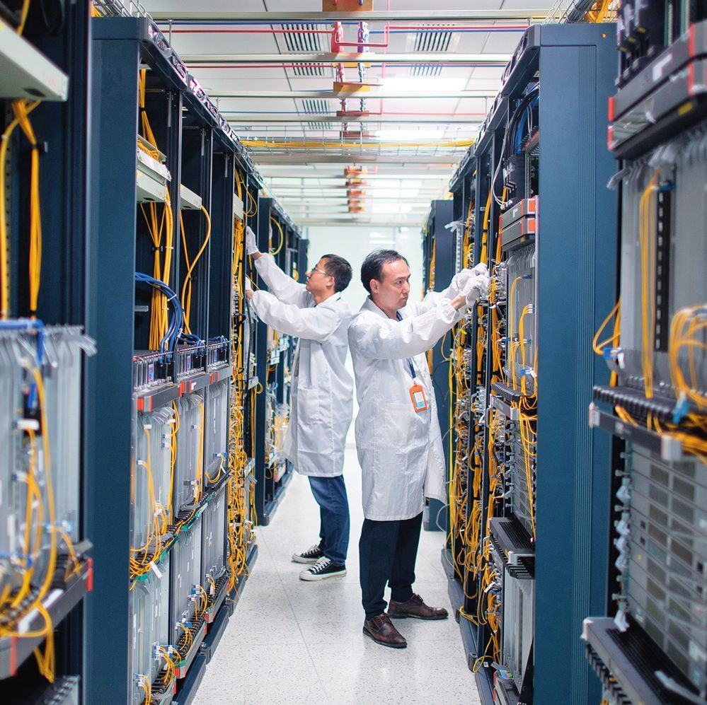 在位于武漢中國光谷的光電器件研發(fā)制造商——武漢光迅科技股份有限公司生產(chǎn)車間內(nèi)，技術(shù)人員在光模塊生產(chǎn)線作業(yè)（2023年4月11日攝）。程敏攝/本刊