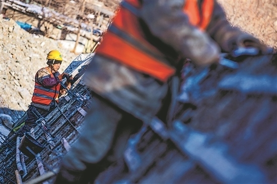 1月3日，房山區(qū)，工人正在雙泉河修筑堤壩。